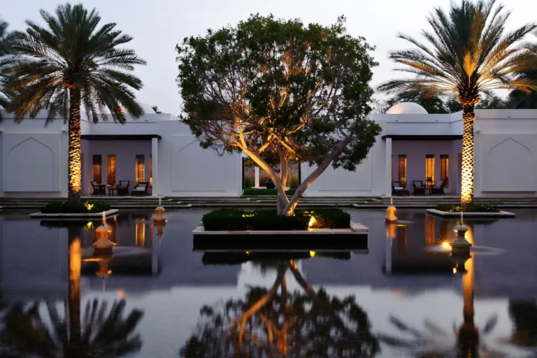 Bäume spiegeln sich in diesem symmetrisch bepflanzten Wasserbecken in einer Luxushotelanlage im Oman. Sie planen eine Reise in den Oman und suchen nach dem perfekten Hotel? Katharina Fenners kennt sich im Nahen Osten hervorragend aus und berät Sie individuell und persönlich.