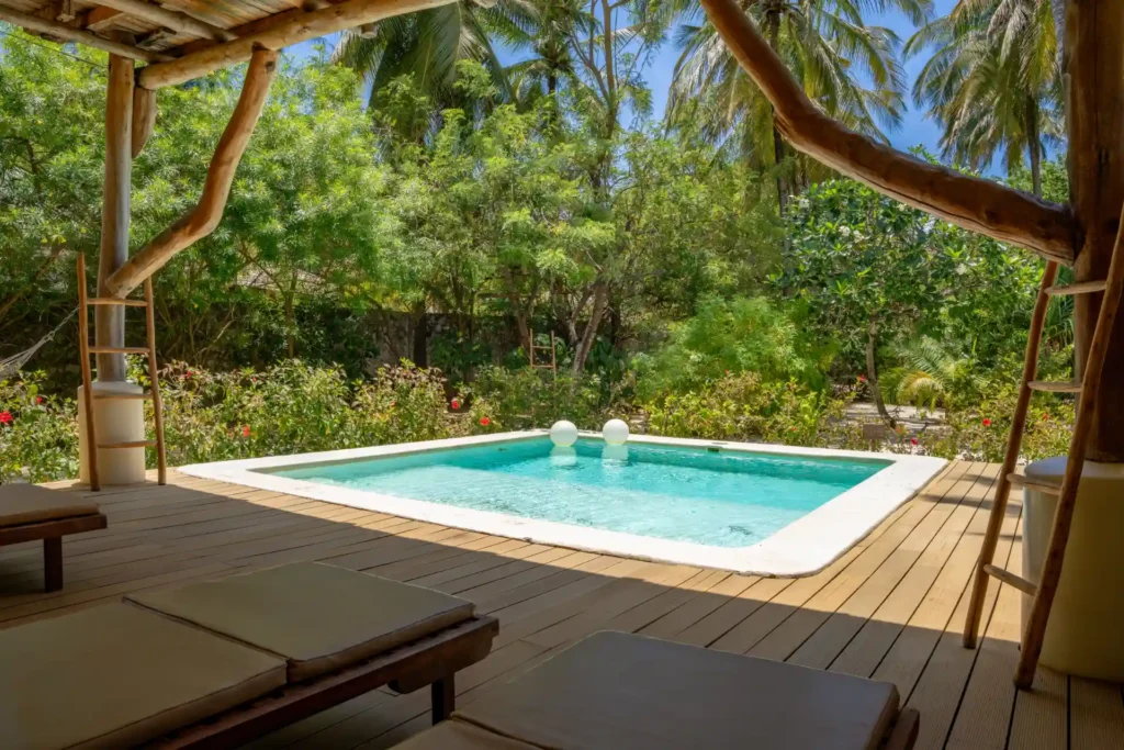 Der Pool dieses Deluxe-Familienzimmers ist eingebettet in tropische Vegetation und liegt doch ganz nah am weißen Traumstrand Sansibars. Individuell buchbar bei Fenners Reisen!