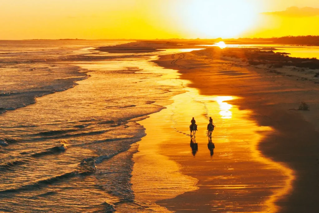 Reiter an einem Strand der Ostalgarve im Sonnenuntergang. Reitstunden an der ruhigen Praia Verde zählen zu den Highlights, die das Boutiquehotel Octant Praia Verde zu bieten hat. Der Aufenthalt kann bei Fenners Reisen gebucht werden!