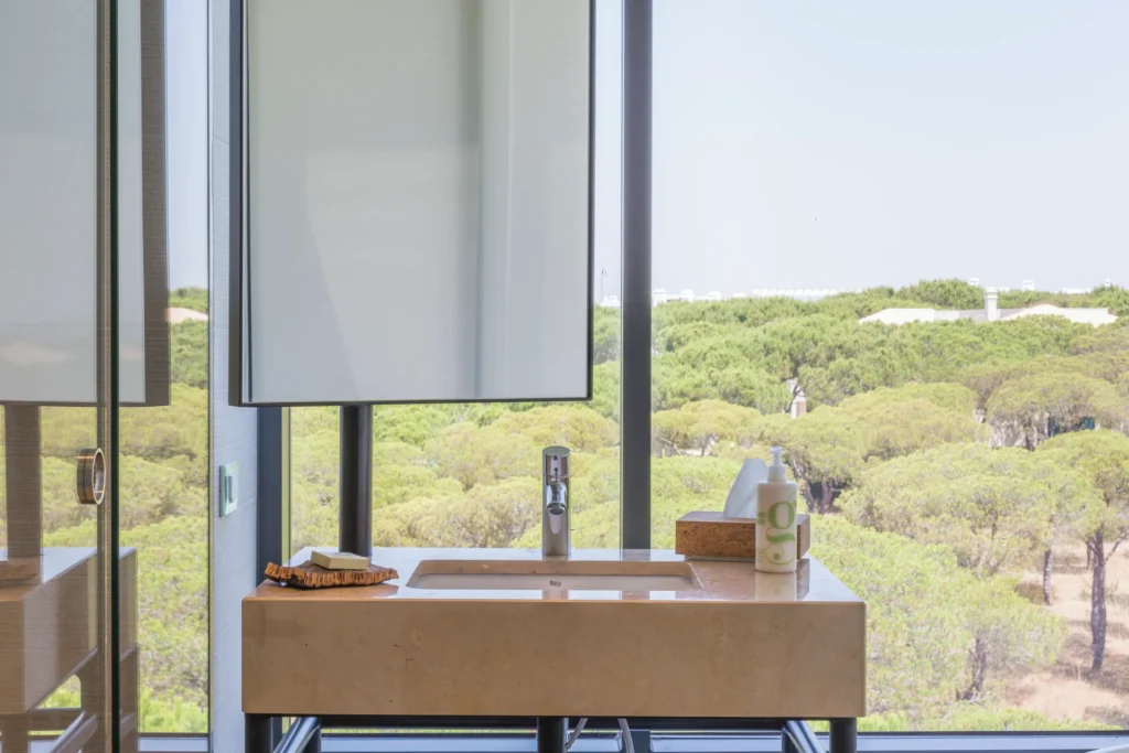 Badezimmer eines Deluxe-Zimmers mit Meerblick. Ein Naturspaziergang durch einen Pinienwald trennt das Hotel vom ruhigen Strand. Sie planen eine individuelle Portugalreise? Portugal-Expertin Katharina Fenners berät Sie persönlich!