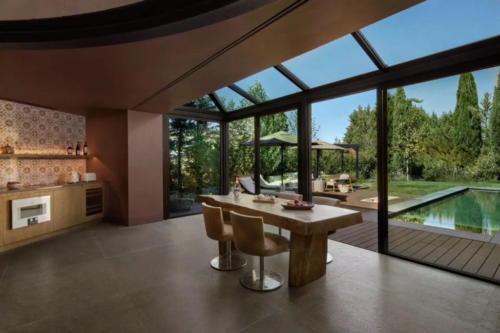 Küche und Essbereich dieser Pool-Villa mit zwei Schlafzimmern in Portugal erlauben durch große Glasfronten weite Blicke auf den eigenen Pool und die grüne Landschaft. Individuell buchbar für Ihre Luxusreise nach Portugal bei Fenners Reisen!