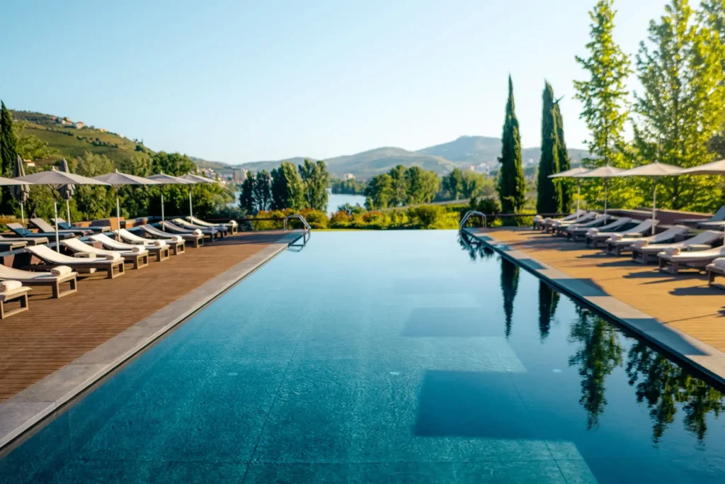 Der Infinity Pool dieses Luxusresorts in Portugal erlaubt prächtige Blicke über Weinberge und den mächtigen Douro-Fluss. Sie suchen ein exklusives Resort für einen besonderen Portugal-Urlaub? Katharina Fenners berät Sie individuell!