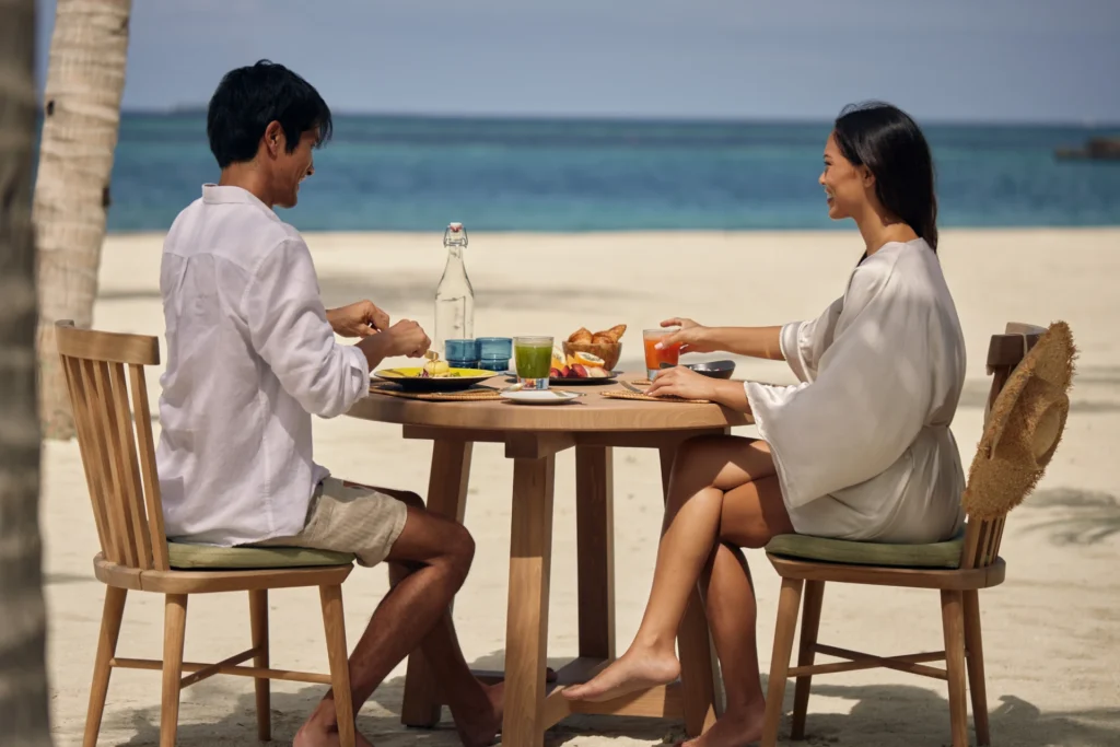 Paar genießt ein Essen barfuß am Strand - das Six Senses Kanuhura zählt zu den ultimativen Barfuß-Resorts der Malediven. Katharina Fenners gestaltet Ihren maßgeschneiderten Aufenthalt!