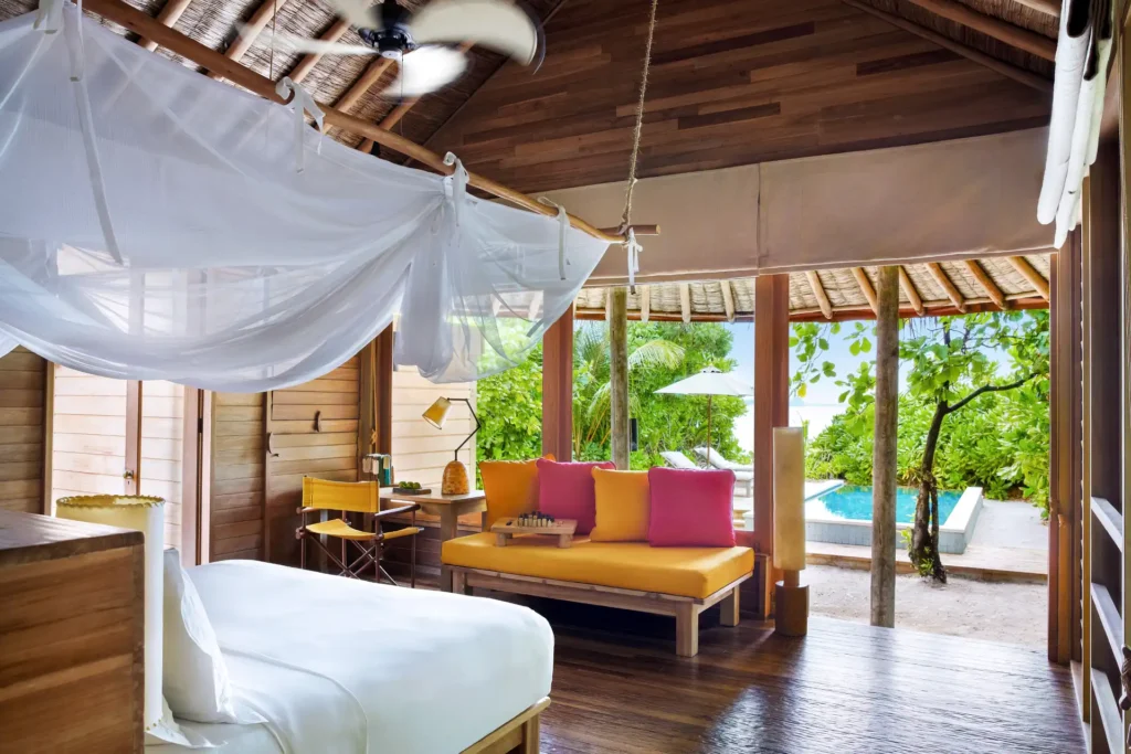 Schlafzimmer einer Strandvilla mit Pool und Ozeanblick auf einer abgeschiedenen Insel der Malediven. Sie planen eine Malediven Luxusreise? Katharina Fenners kennt die schönsten Inseln mit den besten Resorts und berät Sie individuell!