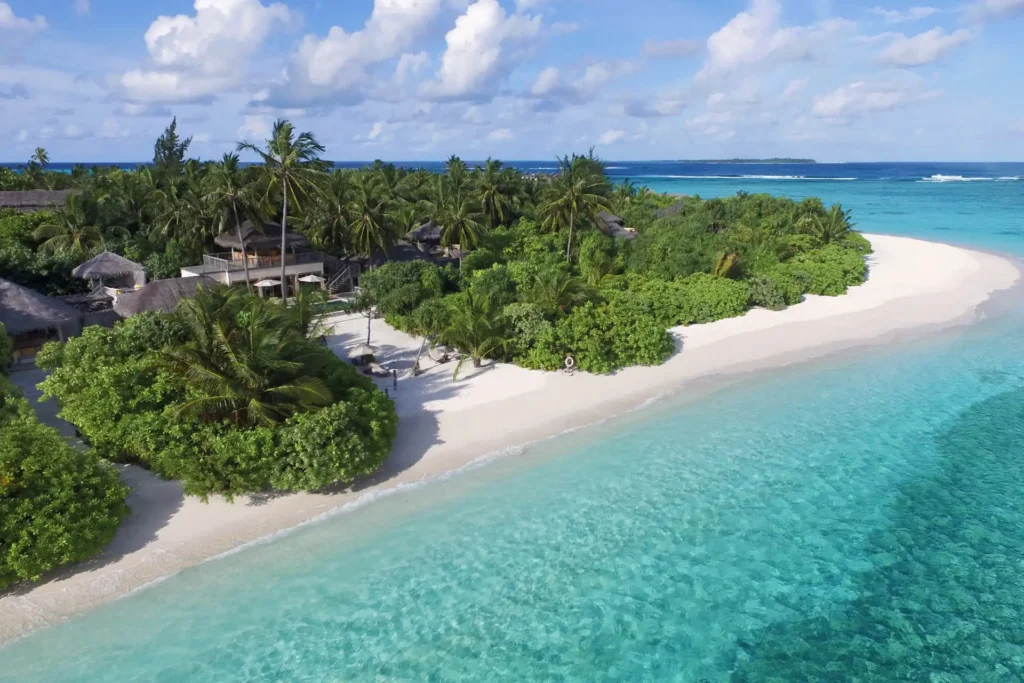 Blick aus der Luft auf eine opulent zwische üppigem Grün liegende Strandvilla mit zwei Schlafzimmern, Pool und Ozeanblick, buchbar für einen exklusiven Malediven Luxusurlaub mit Barfuß-Feeling bei Fenners Reisen.