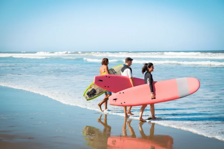 Surfer am kilometerlangen Sandstrand vor dem ROBINSON Club Agadir. Buchen Sie einen individuellen Cluburlaub bei Fenners Reisen!