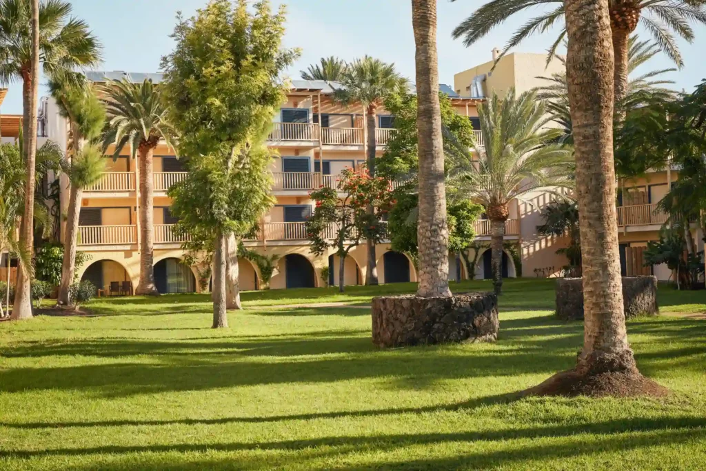 Das niedrige Nebengebäude mit Blick auf die weitläufige Gartenanlage des ROBINSON Jandia Playa. Sie planen einen Adults-only-Cluburlaub mit viel Sport und Wellness, direkt am Strand? Ich arrangiere Ihren individuellen Aufenthalt!