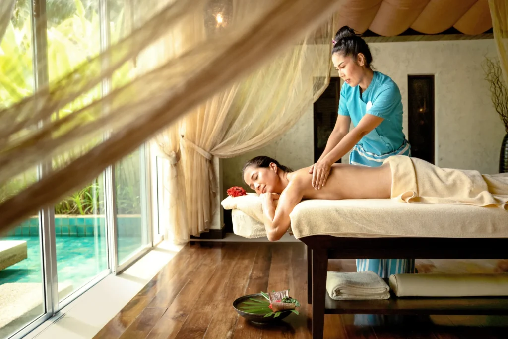 Eine Frau genießt die wohltuende Massage mit Blick auf den Ruhepool des ROBINSON Khao Lak - Wellness und Sport werden hier groß geschrieben! Buchen Sie einen unvergesslichen Cluburlaub in Thailand bei der Reiseexpertin Katharina Fenners!