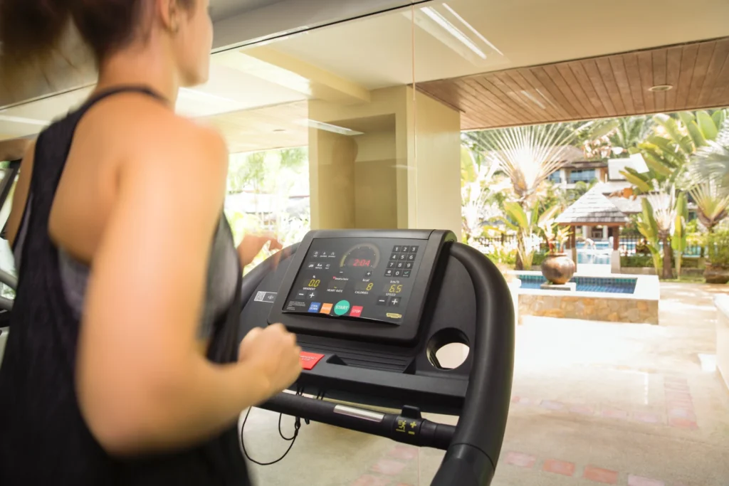 Eine Frau beim Fitness mit Blick auf die tropische Anlage des ROBINSON Khao Lak. Buchen Sie einen individuellen Cluburlaub in Thailand bei Fenners Reisen!