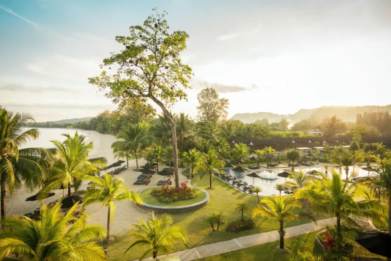 Blick auf die herrliche, tropisch grüne Anlage des ROBINSON Khao Lak zwischen Bergen und flach abfallendem Strand. Buchen Sie einen unvergesslichen Cluburlaub in Thailand bei Fenners Reisen!