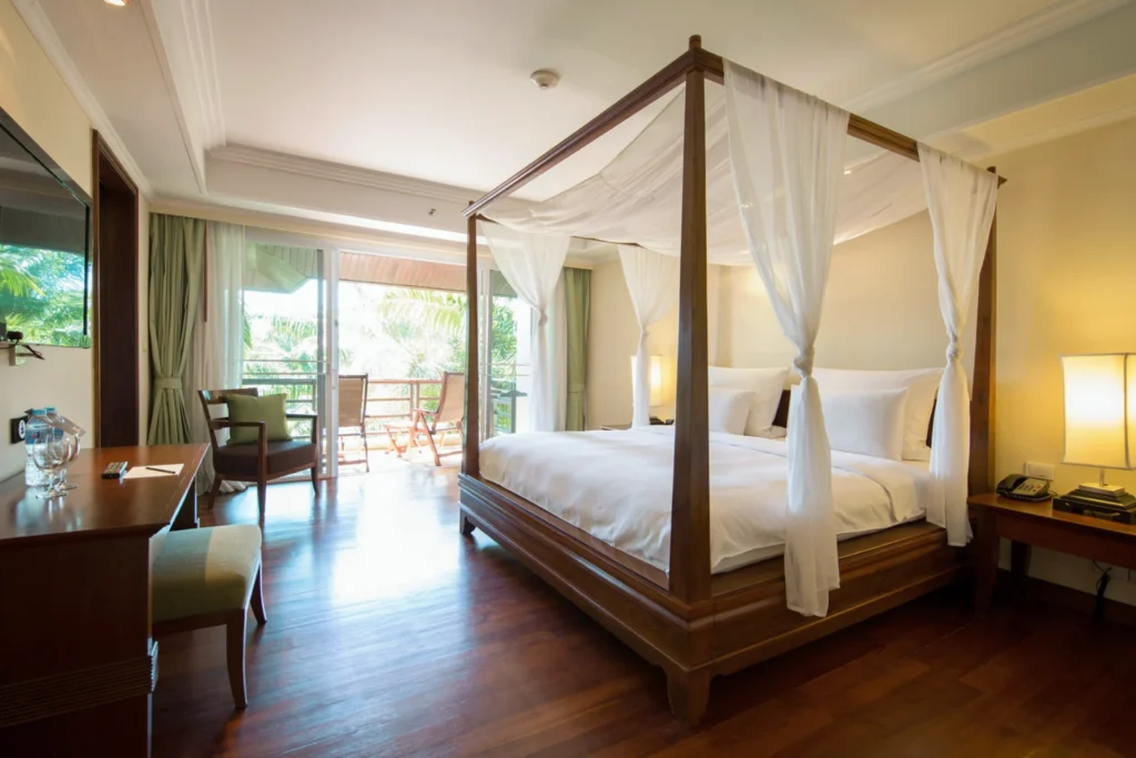 Diese Superior Suite des ROBINSON Khao Lak mit Himmelbett und möbliertem Balkon kann bei Fenners Reisen individuell gebucht werden.