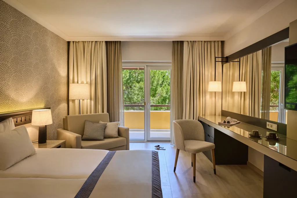 Ruhige Farben und Blick ins Grüne prägen dieses Zimmer des ROBINSON Nobilis in der Türkei. Sie planen einen Cluburlaub an der türkischen Riviera? Katharina Fenners findet die passende Unterkunft für Sie und gestaltet Ihren Aufenthalt individuell.