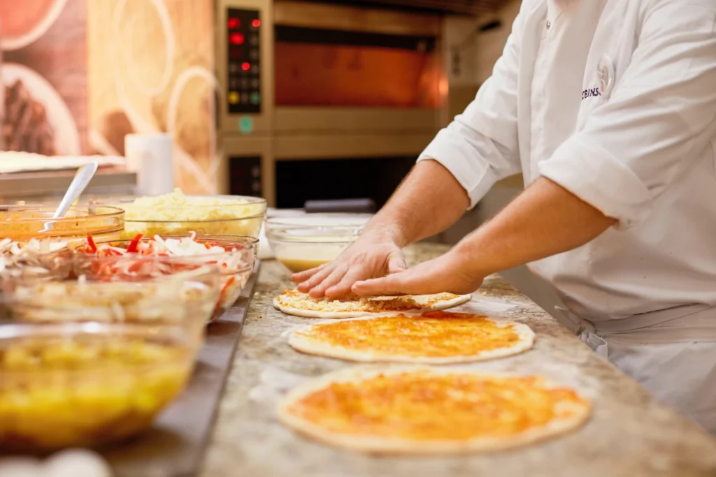 Ein Koch beim Zubereiten türkischer Pizza - der Aufenthalt im ROBINSON Nobilis an der türkischen Riviera ist ein kulinarischer Genuss! Individuell buchbar bei Fenners Reisen.