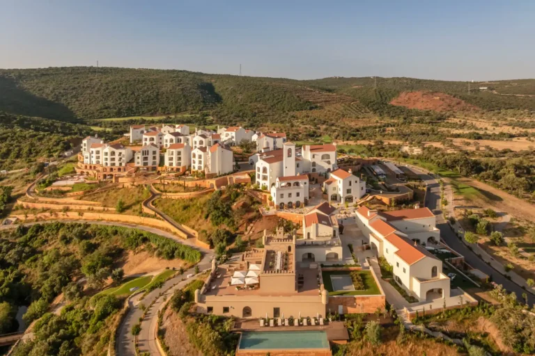Das Viceory at Ombria Algarve aus der Luft gesehen, umgeben von sanften Hügeln und im Stil eines portugiesischen Dorfs. Perfekt für einen naturnahen Portugal Luxusurlaub oder eine Golfreise nach Portugal! Katharina Fenners gestaltet Ihren Aufenthalt individuell.