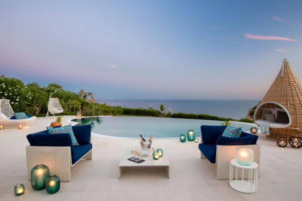 Terrasse und Pool der Vila Praia in der Algarve sind mit modernen Möbeln akzentuiert und erlauben weite Blicke über das Meer. Die Villa ist individuell buchbar für eine Luxusreise nach Portugal - bei der Portugalexpertin Katharina Fenners.