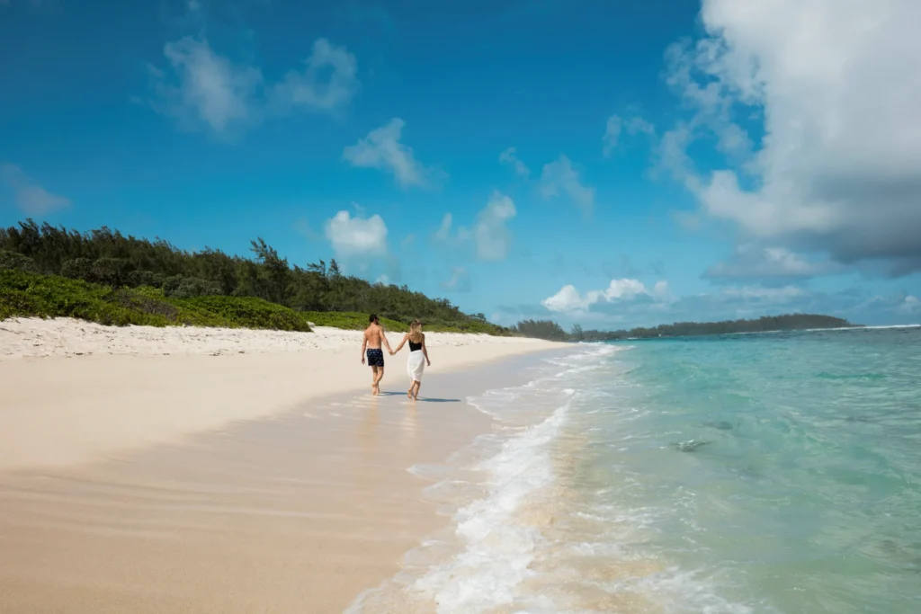 Paar genießt den endlosen Sandstrand vor dem Constance Le Chaland Mauritius. Das Resort liegt an einem der unberührtesten Küstenabschnitte der Insel Mauritius - perfekt für eine romantische Auszeit zu zweit. Katharina Fenners gestaltet Ihre Mauritiusreise individuell!