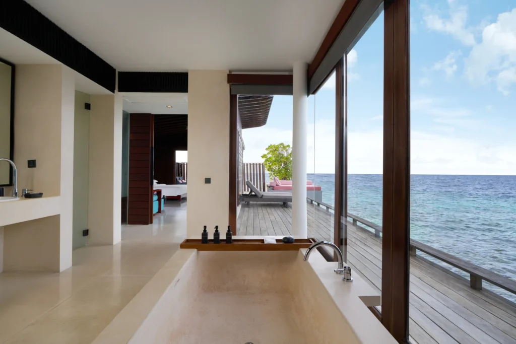 Natursteinwanne mit Blick auf den Ozean in einer Überwasser-Villa des Park Hyatt Maldives Hadahaa. Jetzt Ihre Luxusreise auf die Malediven bei Fenners Reisen buchen!