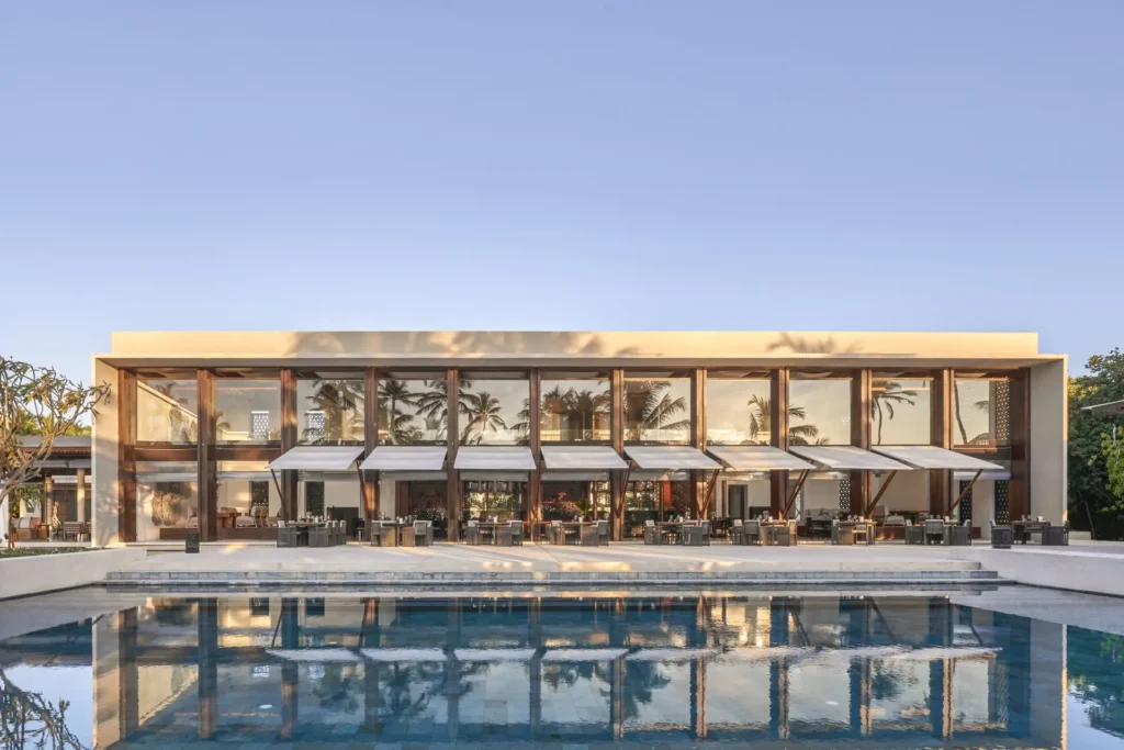 Das Hauptrestaurant und Pool des Park Hyatt Maldives Hadahaa. Hier treffen sich hervorragende Kulinarik und stilvolle Entspannung! Individuell buchbar bei Fenners Reisen!