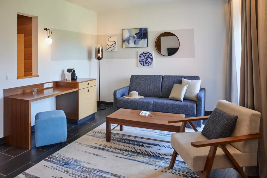 Komfortables Wohnzimmer einer Klassik-Suite des ROBINSON Quinta da Ria, mit Sofa, Sessel und Schreibtisch. Jetzt bei Fenners Reisen buchen!