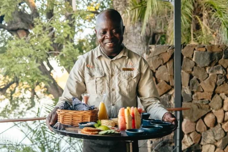 Verwöhnung inklusive bei African Bush Camps Verwöhnung rund um die Uhr inklusive - ein Mitarbeiter von African Bush Camps präsentiert strahlend ein großes Tablett voller Köstlichkeiten. Eine Reise zu Top-Lodges in Sambia und Simbabwe lässt sich hervorragend mit dem Rovos Rail in Südafrika kombinieren. Katharina Fenners verwirklicht Ihre Traumreisen in Afrika und weltweit!