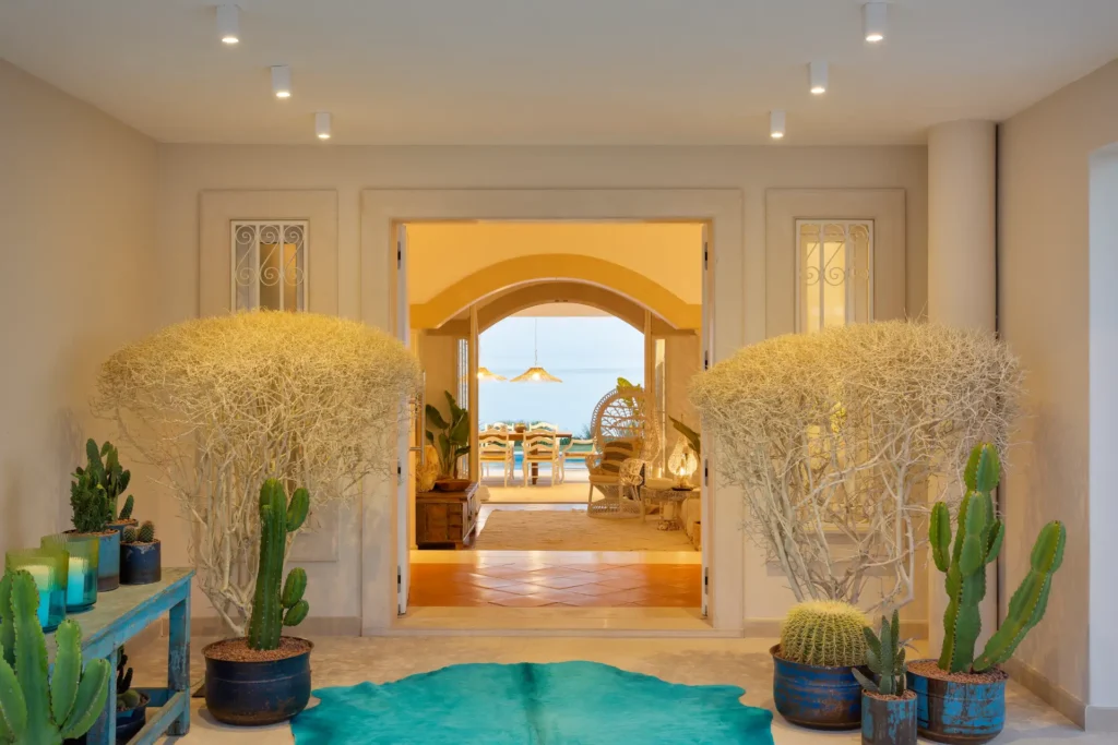 Offener Blick vom opulent gestalteten Eingangsbereich bis zum Essbereich und hinaus in den Garten mit Pool und Meer vor der Tür - die Villa Hibiscus Beach House an der Algarve kann individuell bei Fenners Reisen gemietet werden.