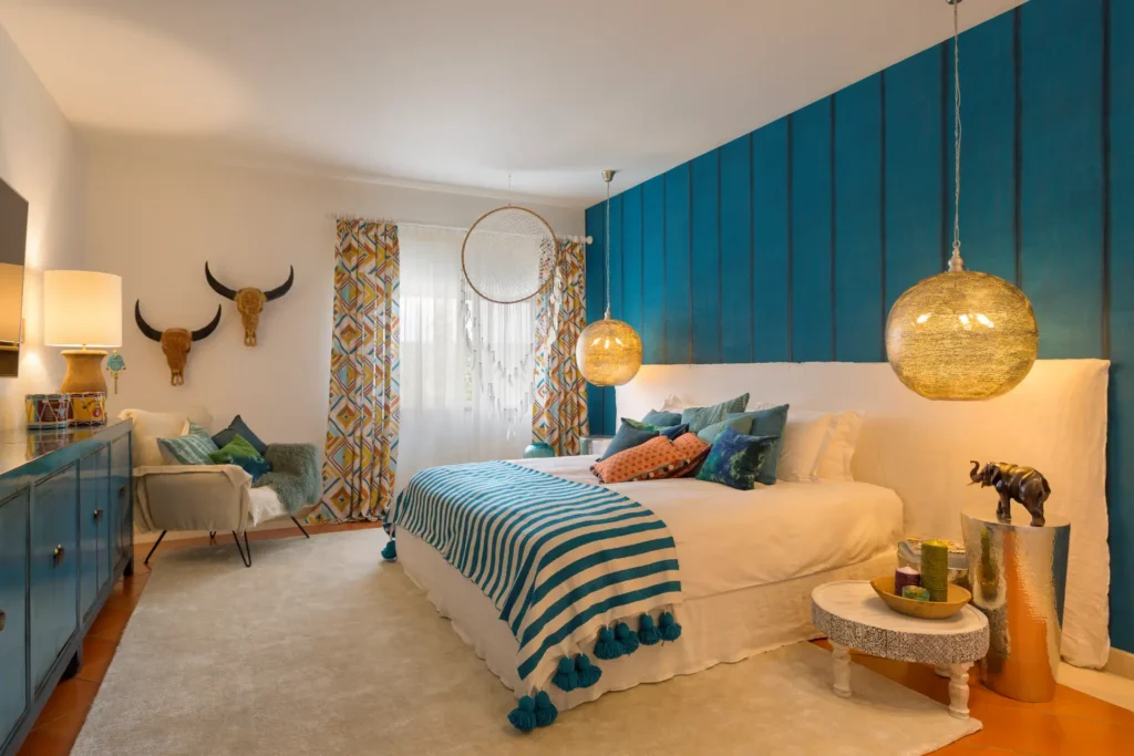 Hängeleuchten, Traumfänger, Skulpturen und farbige Akzente machen dieses Schlafzimmer der Villa Hibiscus Beach House an der Algarve einzigartig. Sie möchten eine Luxusvilla in Portugal mieten? Katharina Fenners berät Sie individuell!