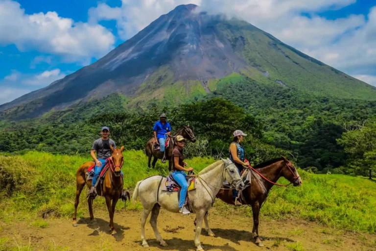 Reiter und Reiterinnen vor dem Vulkan El Arenal - auch Ausritte können während einer Reise durch Costa Rica mit Fenners Reisen gebucht werden.