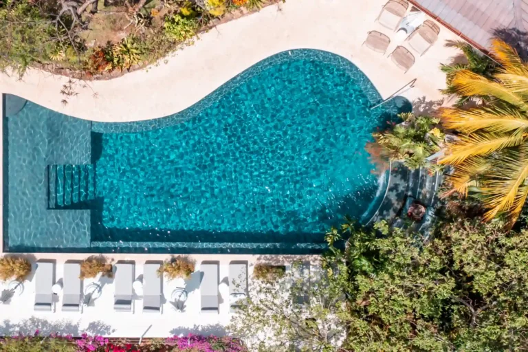 Blick aus der Luft auf den geschwungenen Pool des Wellness-Hotels The Retreat Costa Rica, das Gästen ab 16 Jahren ganzheitliche Erholung in atemberaubender Naturkulisse verspricht. Individuell buchbar bei Fenners Reisen!