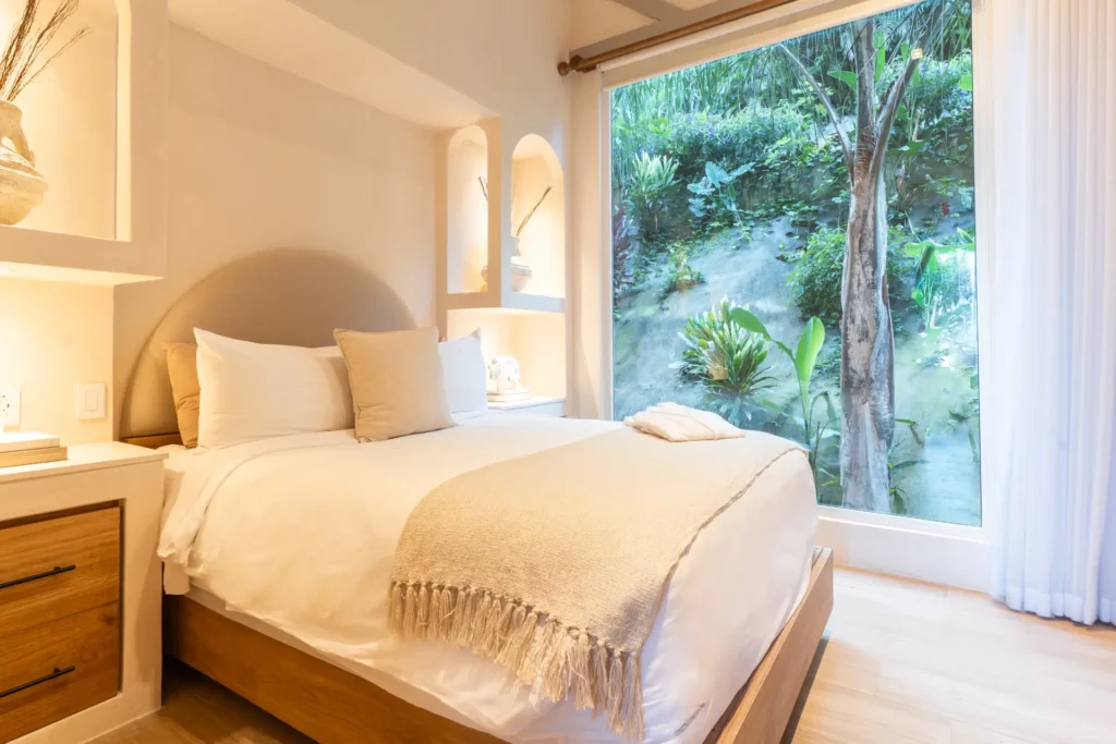 Dieses Schlafzimmer der Santosha Residence in Costa Rica bietet bodentiefe Blicke ins tropische Grün - individuell buchbar für bis zu sechs Personen bei Fenners Reisen!