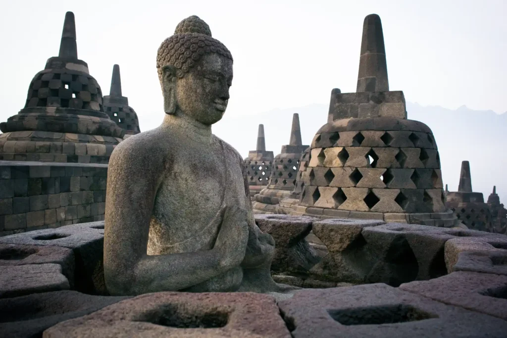 Stupas und Buddha Statue in Borobudur, unweit des Luxusresorts Amanjiwo, das bei Fenners Reisen individuell gebucht werden kann.