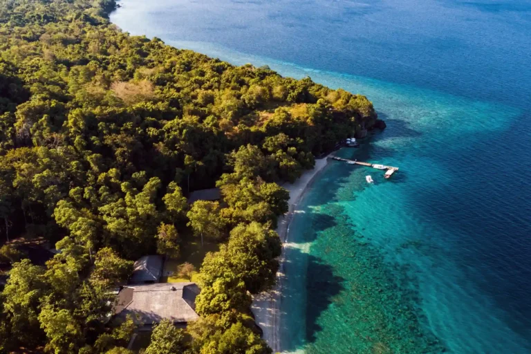 Das Amanwana Luxusresort und Camp auf Moyo Island aus der Luft gesehen - eng umschlungen von Urwald liegt es direkt am türkisblauen Meer und bietet eine Vielzahl an Erlebnissen. Buchbar bei Fenners Reisen - auch in Kombination mit einer Bali Rundreise!