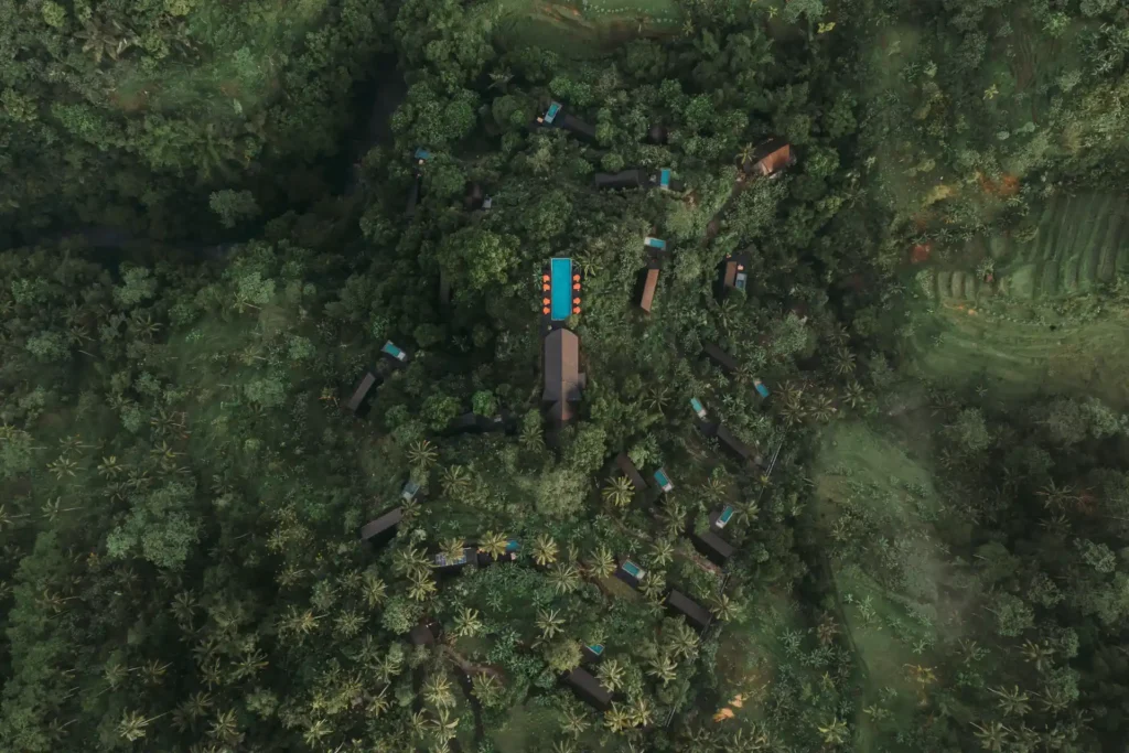 Vogelperspektive auf das Buahan A Banyan Tree Escape Adults-Only-Resort in Bali, das eng vom Regenwald umschlungen ist. Wer tiefe Erholung, viel Verbindung zur Natur und authentische Erfahrungen in Indonesien sucht, ist hier richtig! Katharina Fenners gestaltet Ihren Aufenthalt individuell.