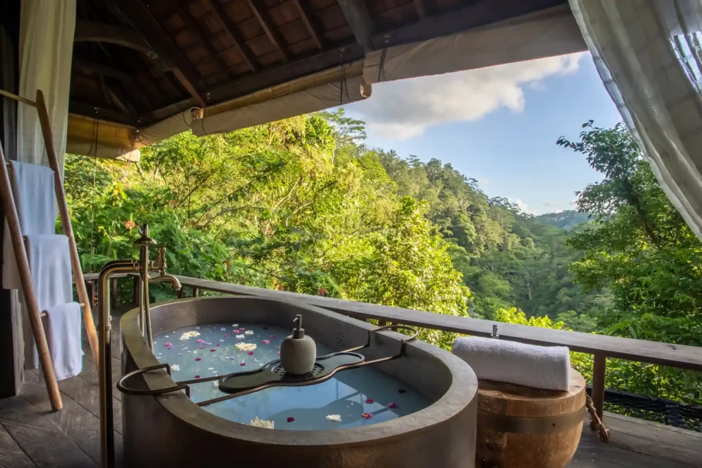 Mit Blüten verzierte Badewanne einer Flusstal-Bale mit Pool des Buahan, A Banyan Tree Escape. Individuell buchbar bei Fenners Reisen.