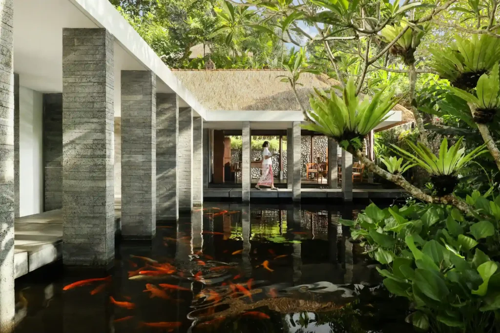 Entspannung zwischen Koiteichen - Holzstege führen zu den Behandlungsräumen des COMO Shambhala Retreat bei Ubud. Jetzt Ihre Wellnessauszeit in Bali mit Fenners Reisen planen!