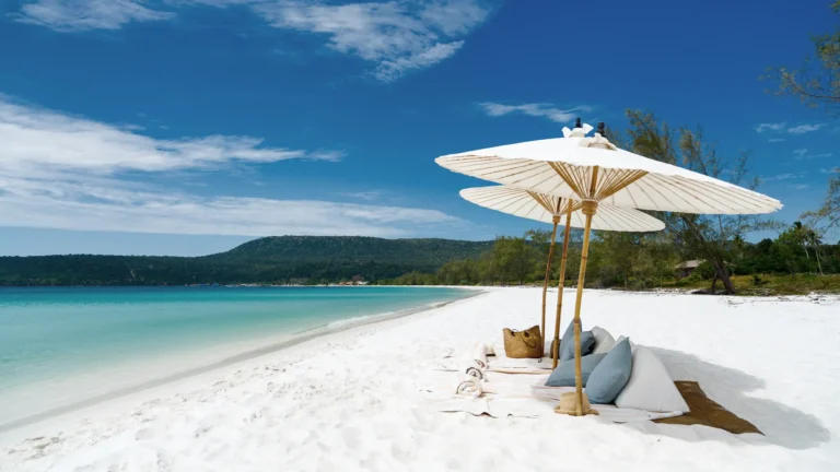 Sonnenschirme und Kissen im tiefweißen Sand der Bilderbuchinsel Song Saa - ein grandioser Abschluss jeder Kambodscha Rundreise, individuell gebucht bei Fenners Reisen!