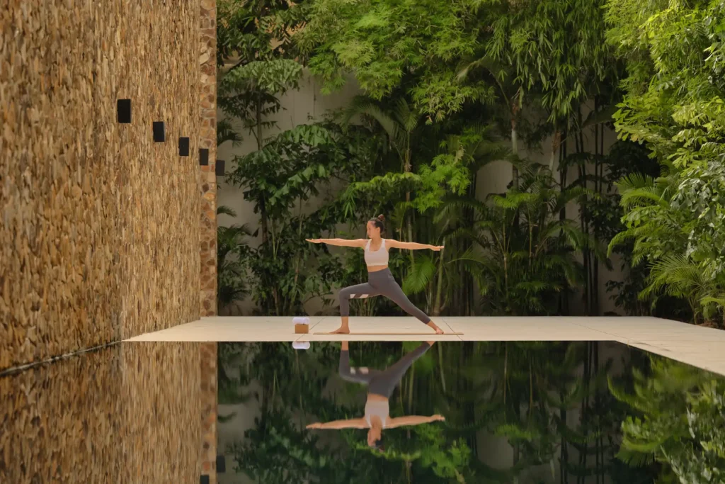 Yoga vor dem Reflexionsbecken eines intimen Luxusresorts bei Angkor Wat. Sie planen eine Luxusreise durch Kambodscha? Katharina Fenners kennt die besten Resorts des Landes und berät Sie persönlich.