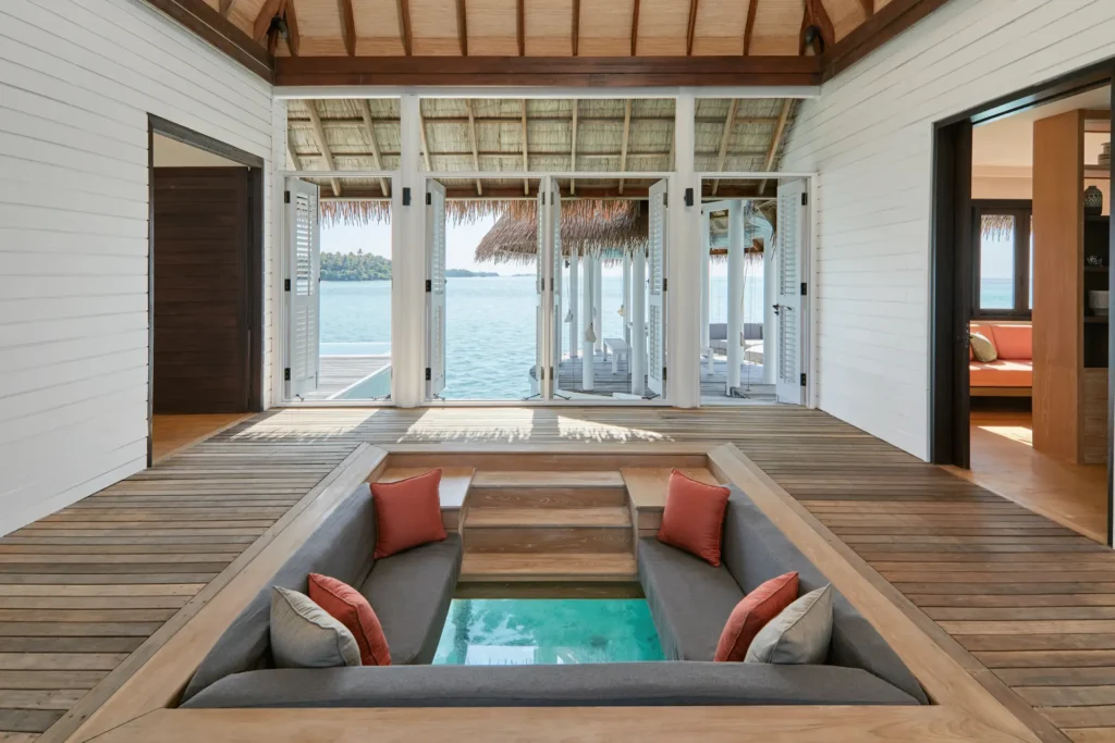 Highlight des COMO Maalifushi: Der Sitzbereich rudn um einen Glasboden in der Maalifushi-Wasservilla. Individuell buchbar bei Fenners Reisen!