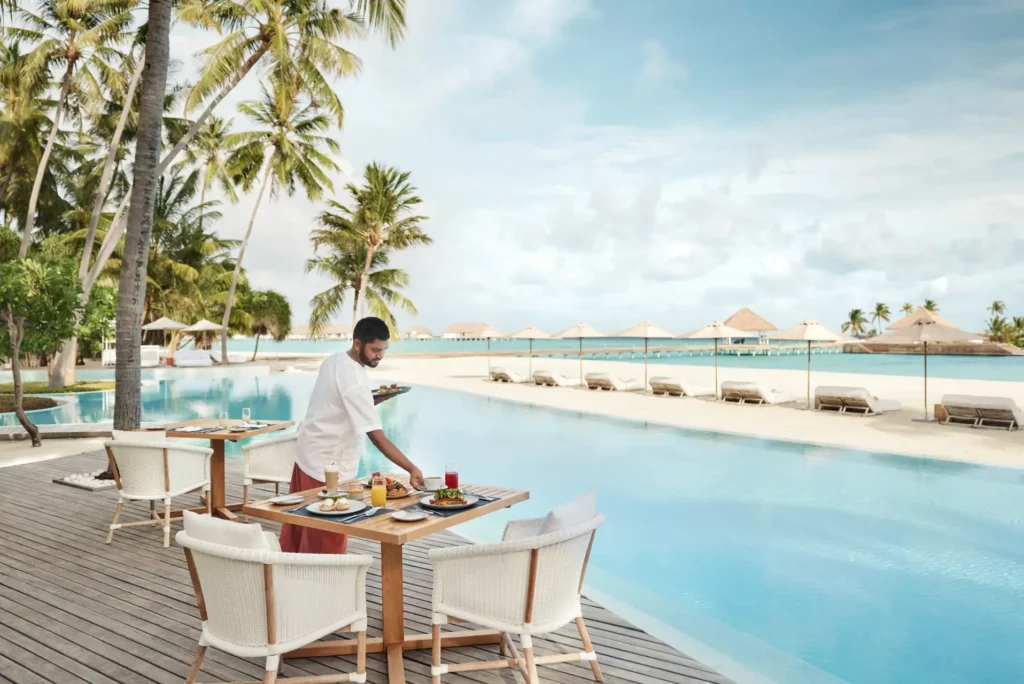 Frühstück am Pool mit Meerblick in einem Luxusresort auf den Malediven. Sie planen eine Maldiven Luxusreise oder einen Familienurlaub in einem exklusiven Barfuß-Resort? Katharina Fenners berät Sie persönlich!
