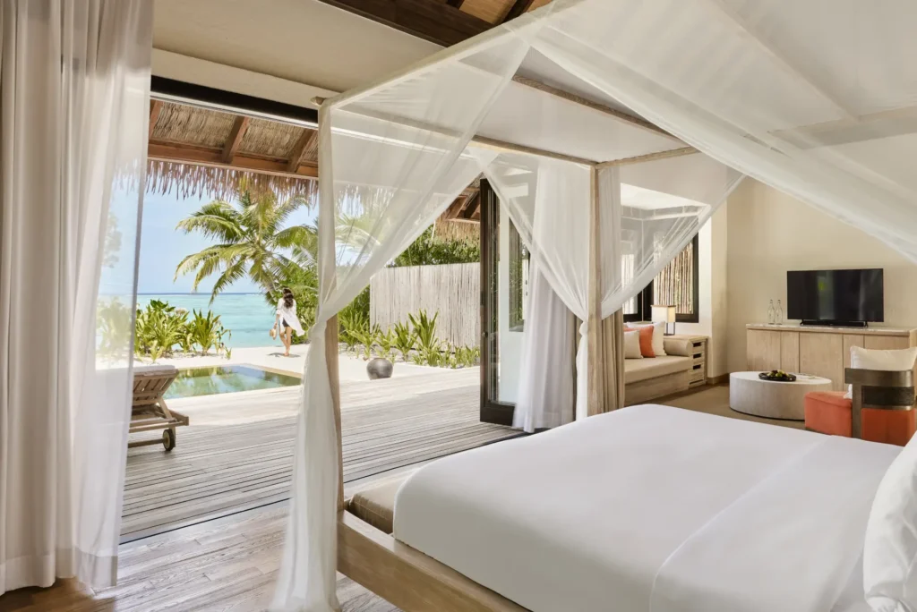 Die Strand-Suite des COMO Maalifushi öffnet sich zum privaten Pool, dahinter glitzert das Meer. Buchbar für Ihren Maledivenurlaub bei Fenners Reisen.